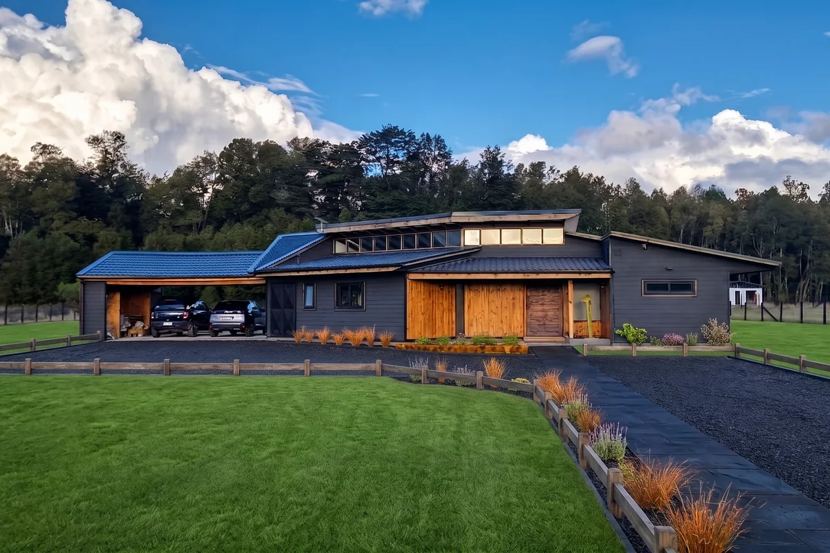 Casa Pitra II en Villarrica: vista general de la vivienda con techo inclinado y revestimiento de madera, obra de CCP Arquitectura