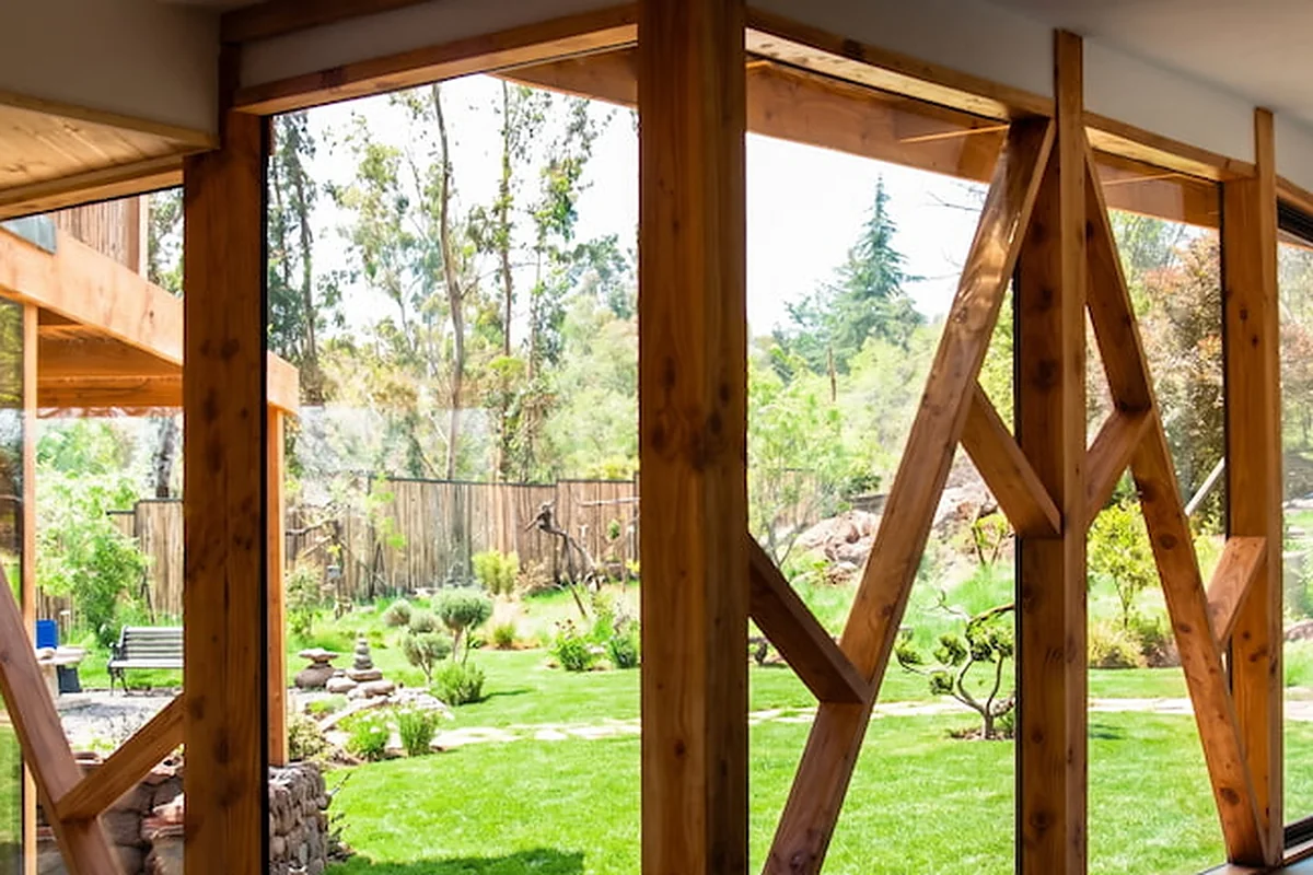 Casa Minillas en Santiago: estructura de madera vista desde el interior hacia el jardín, obra de CCP Arquitectura