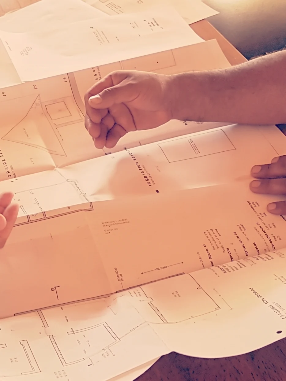 Dos profesionales revisando planos de arquitectura sobre una mesa: diseño y regularización de viviendas en CCP Arquitectura